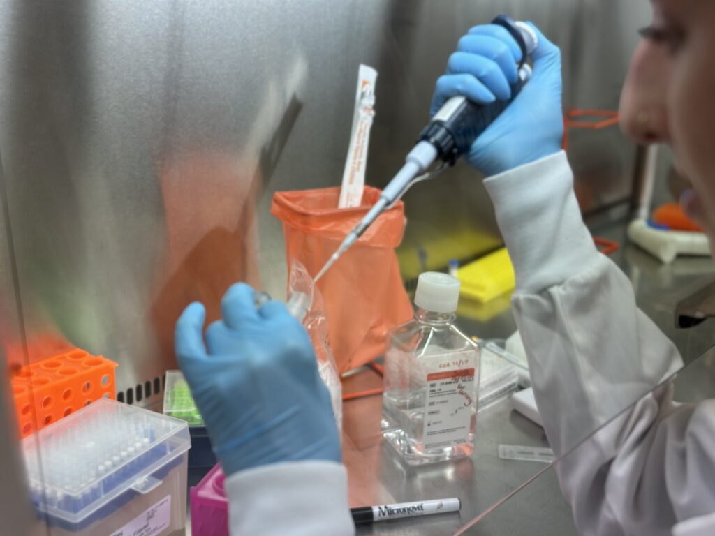 Scientist using mechanical pipettor to perform protein engineering services.